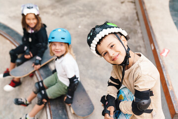 Happy cheerful kids with skateboards at the ramp - obrazy, fototapety, plakaty