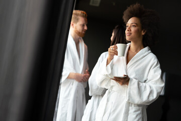 Portrait of a beautiful young woman drinking tea dressed in a bathrobe in a wellness spa center
