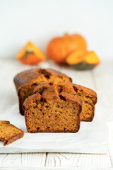 Pumpkin bread cake with half loaf sliced on white wooden background