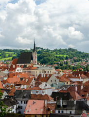 Obraz premium Vertical Rooftop view of Cesky Krumlov and high St Vitus church, famous touristic old town in Czech Republic in summer.