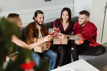 Image of friends giving presents to each other while drinking wine
