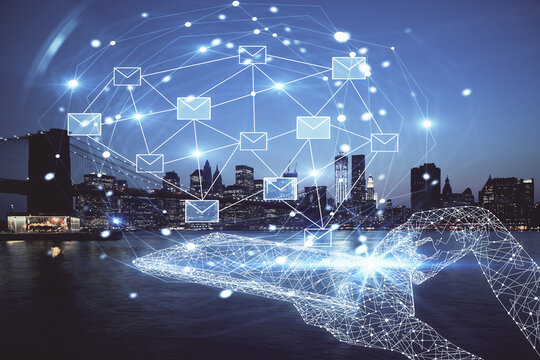 Double exposure of envelop hologram flying from gadget and city view background. Concept e-mail.