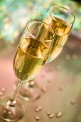 Detailed photo of colorful champagne glasses with pearls, glitter, ribbons and ornaments. Selective focus - extremely shallow depth of field.