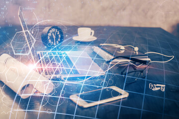 Double exposure of desktop with computer and world map hologram. International data network concept.