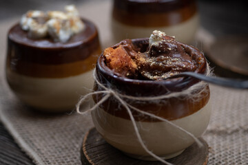 Pumpkin mousse topped with ganache and s'mores served in individual clay pots, rustic fall Thanksgiving dessert