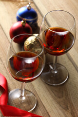 two glasses of red wine and Christmas ornament on a wooden table with copy space for your text