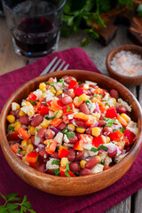 salad with red beans, corn and bell peppers in a wooden salad bowl, selective focus