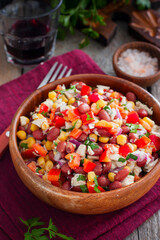 Obraz na płótnie Canvas salad with red beans, corn and bell peppers in a wooden salad bowl, selective focus