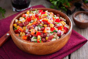 salad with red beans, corn and bell peppers in a wooden salad bowl, selective focus
