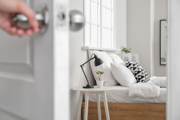 Woman opening door in modern bedroom