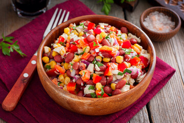 salad with red beans, corn and bell peppers in a wooden salad bowl, selective focus