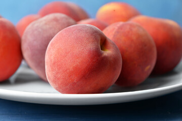 Fototapeta na wymiar Plate with sweet peaches on table, closeup