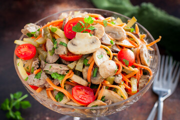 salad with chicken liver, mushrooms and tomatoes in a glass bowl, selective focus