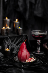 Red wine poached bloody gothic Halloween pears with cream, wine & candles