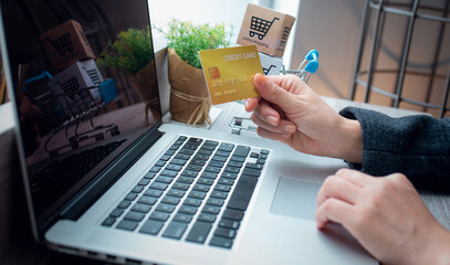 Close up Business woman Hands holding credit card and using laptop for Online shopping,Toned picture,Online shopping,SME, e-commerce, internet banking, spending money,working from home concept.