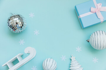 Simply minimal composition winter objects ornament sled fir tree ball gift box isolated blue pastel background. Christmas New Year december time for celebration concept. Flat lay top view copy space