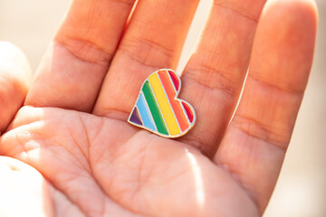 Colorful rainbow heart-shaped icon in hands