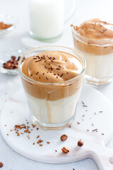 Cold Dalgon coffee in a glass on a white background. A trendy drink made from whipped instant coffee and milk. Close up.