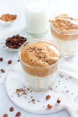 Cold Dalgon coffee in a glass on a white background. A trendy drink made from whipped instant coffee and milk. Close up.