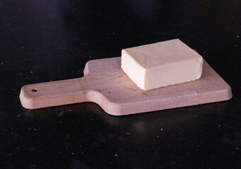 Piece of butter or margarine on a wooden board