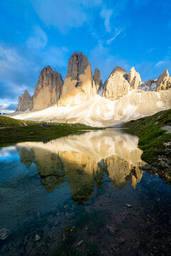 Sunset over Tre Cime di Lavaredo mirrored in Grava Longa lakes, Sesto Dolomites Natural Park, South Tyrol, Italy
