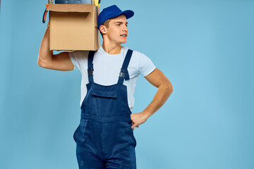 working man in uniform box with tools loader delivery blue background