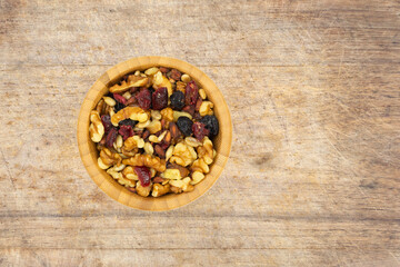 Bowl of healthy trail mix on an old wood cutting board.