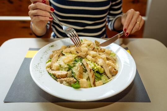 Mulher comendo salada de alface com frango (Cisar Salad)