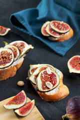 Tasty bruschetta with cream cheese, figs