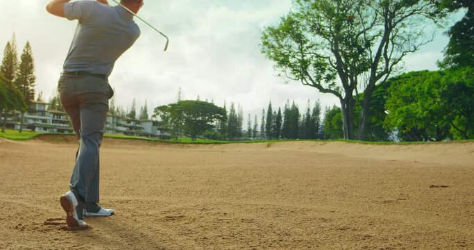 Golfer hits ball out of the sand trap, slow motion