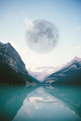 A huge moon over a beautiful landscape of mountains and lake