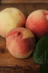 Fototapeta na wymiar Fresh juicy peaches with leaves on the table