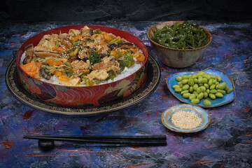 Vegan chirashizushi  made with yuba, shiitake, broccoli and pepper in traditional bowl along with wakame, edamame.