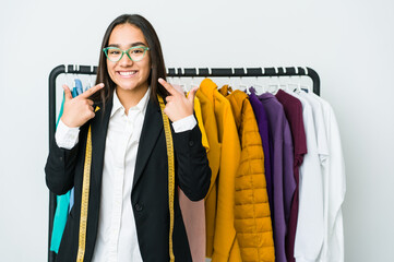 Young asian designer woman isolated on white background smiles, pointing fingers at mouth.