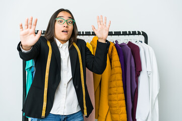 Young asian designer woman isolated on white background being shocked due to an imminent danger