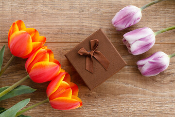 Gift box with tulips on wooden boards.