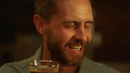Handsome man making toast during dinner. Smiling guy talking with family