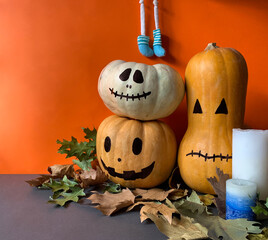 Halloween concept with jack o lantern pumpkins, autumn leaves, candles and spooky character legs
