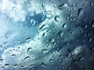Water drops of rain on blue glass background