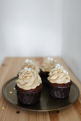 chocolate cupcakes with caramel cream decorated with silver on a gold tray