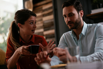 Businessman and businesswoman in office. Two friends drinking coffee while working on the project..