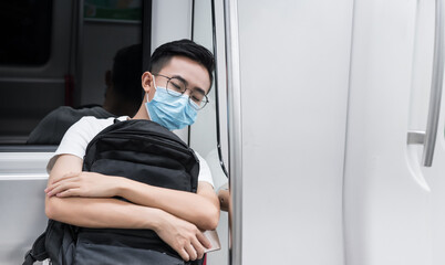 Young man wearing a mask sitting in the subway