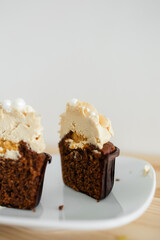 cut chocolate cupcake with caramel cream on a white saucer