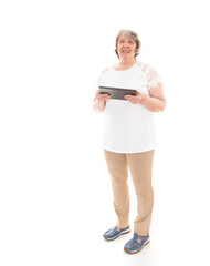 Seniorin hält Tablet in der Hand und lächelt in die Kamera vor weißem Hintergrund