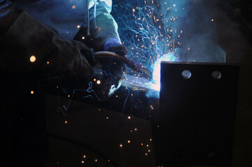 Welder assembling technical steel. Industrial welding of metal structures