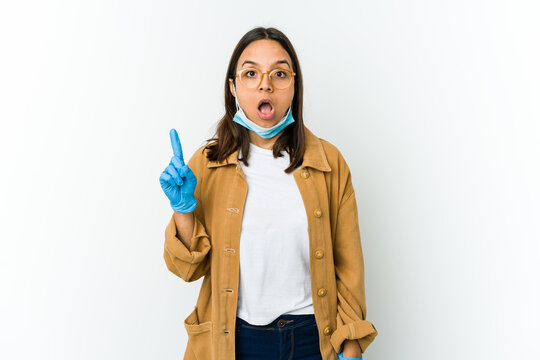 Young Latin Woman Wearing A Mask To Protect From Covid Isolated On White Background Having An Idea, Inspiration Concept.