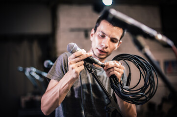 Theater audio technician adjusting an microphones on the scene. Installing and testing the sound...