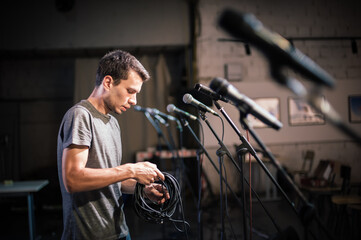 Theater audio technician adjusting an microphones on the scene. Installing and testing the sound...