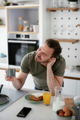 Fototapeta na wymiar Handsome man preparing breakfast at home. Young man enjoying in morning..