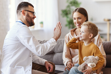 family doctor pediatrician conducts examination of   child boy and giving high five to him  . - 385041330